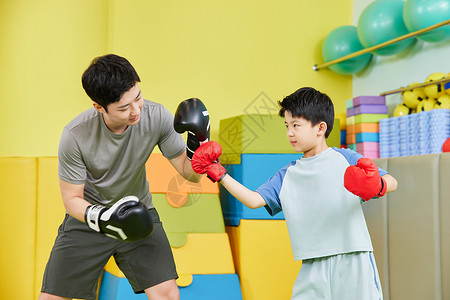 教练带小男孩练习拳击高清图片