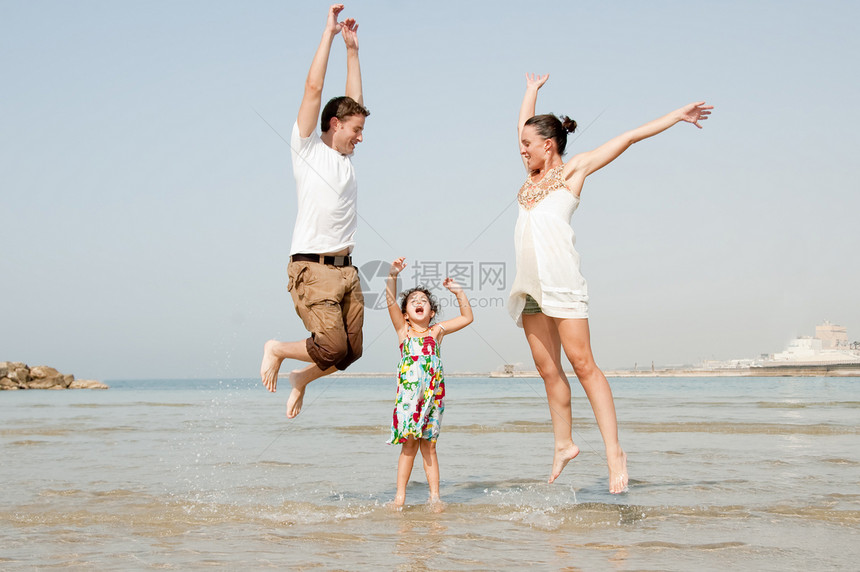 在沙滩上玩耍跳跃的父女俩图片