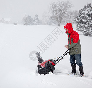 穿着红色大衣的老人在驾车回家途中暴风雪时图片