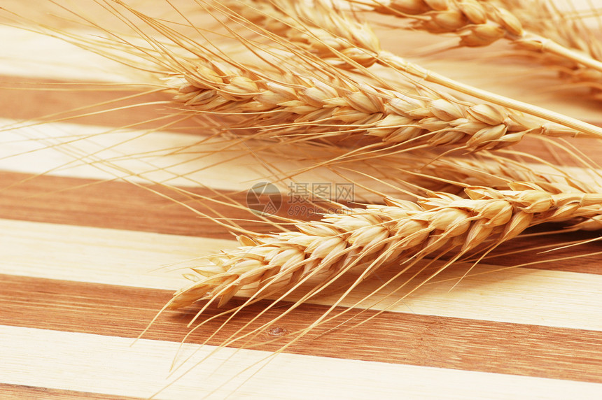 条纹木质背景上的麦穗图片