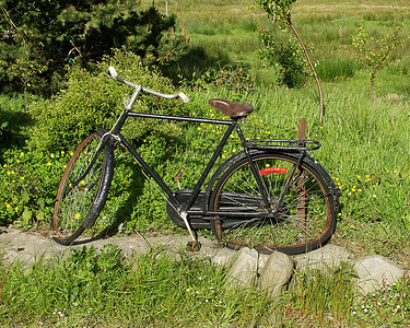 路边破旧的黑色自行车背景图片