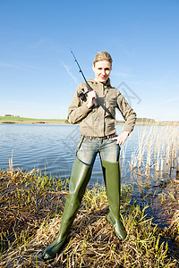 在池塘钓鱼的女人高清图片