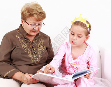可爱的小女孩和她的祖母一起读书图片