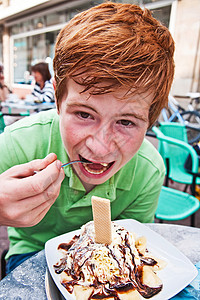 孩子在户外餐桌上吃冰淇淋图片