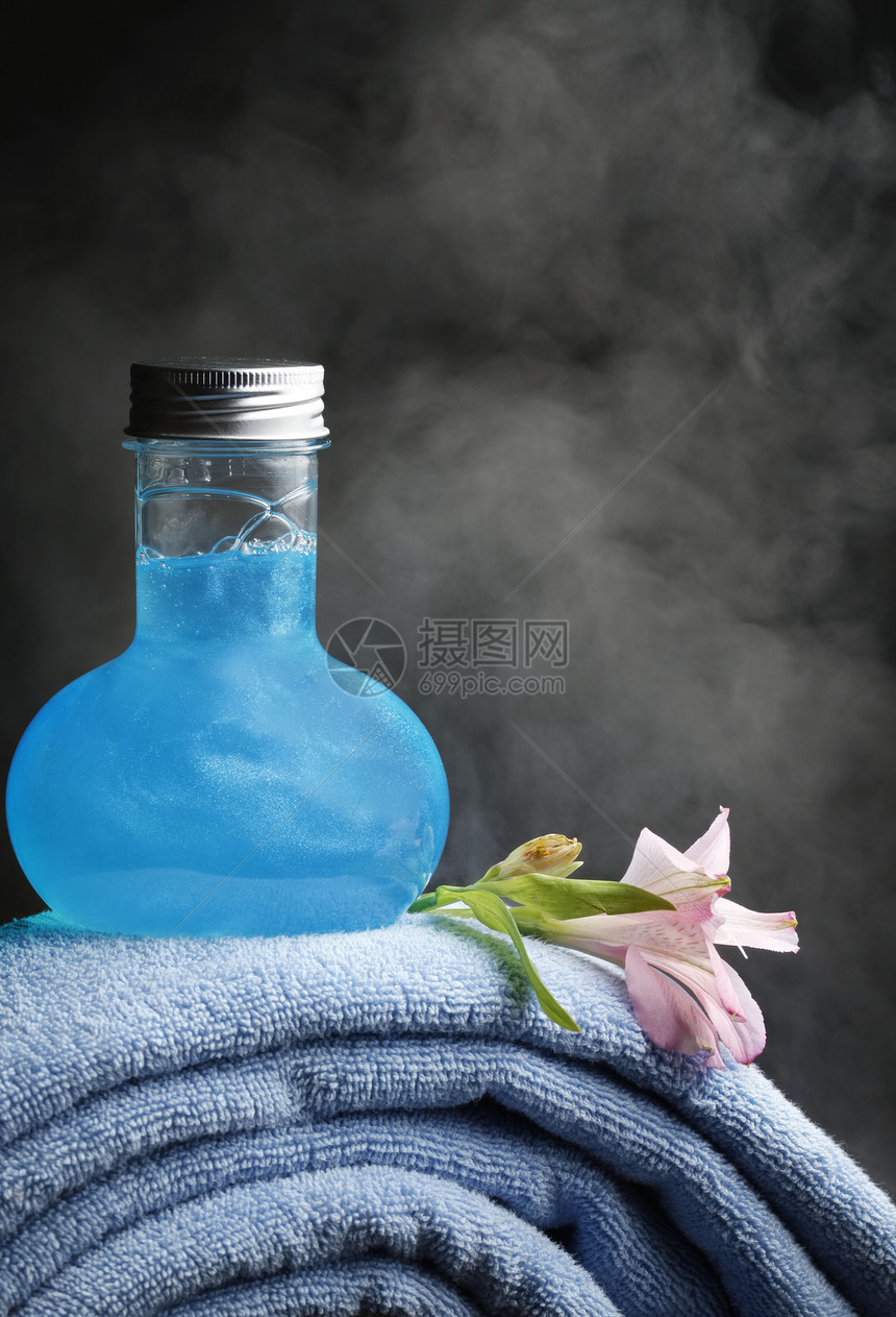 蓝色毛巾和瓶子背景是蓝色洗发水图片