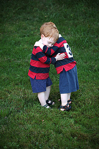 穿着橄榄球服拥抱的双胞胎男婴图片
