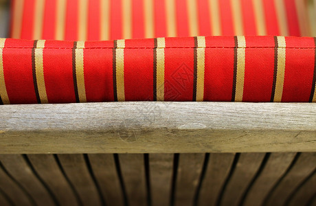 红色和黄色条纹垫子的木制长椅后背照片图片