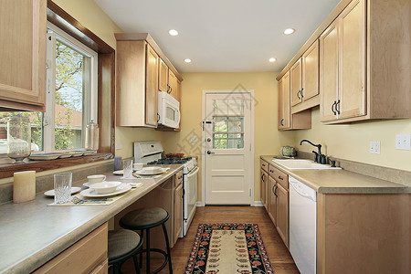 郊区住宅的厨房配有橡木橱柜图片