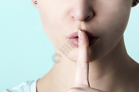 女人把手指放在嘴唇上表示沉默图片