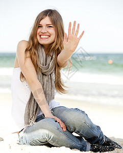 有趣的少女坐在沙滩上图片