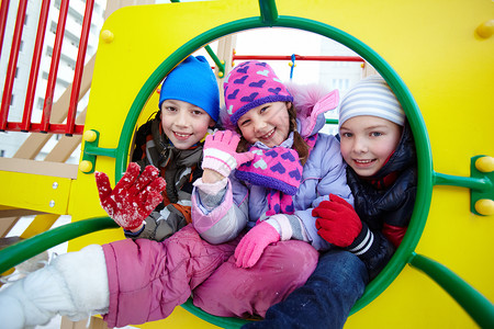 冬天穿冬装的快乐孩子在游乐场玩图片