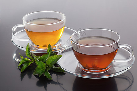 透明杯子绿色茶叶和灰色背景图片