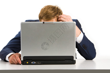 疲惫的商人坐在笔记本电脑前摸头的肖像图片