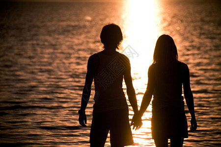 浪漫情侣用双手对方和在日落时仰慕湖图片
