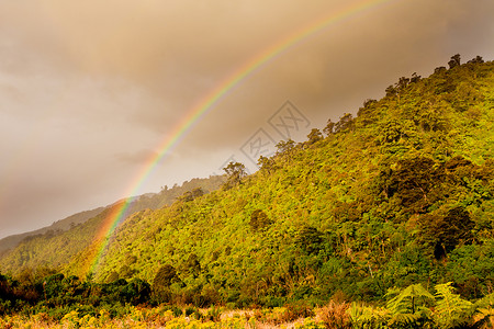 彩虹在新西兰南岛西海岸的山坡上发光图片