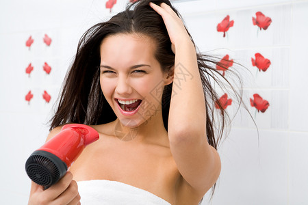 喜悦的女在洗完头发后擦图片