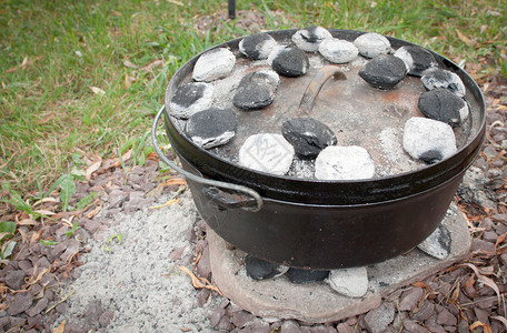 在荷兰烤箱里用木炭加热晚餐图片