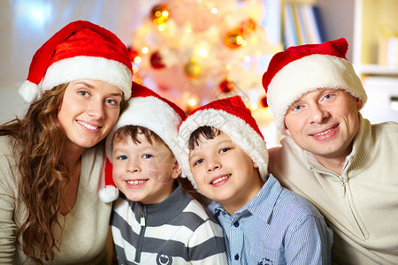 4个幸福的家庭成员在圣诞老人帽子上肖图片