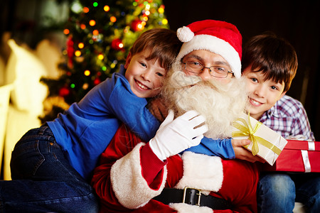 照片快乐的男孩拥抱圣诞老人和可爱图片