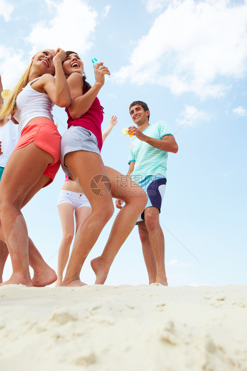 喜悦的年轻朋友在海滩派对图片