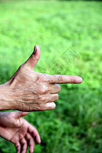 男人的手食指放在绿色背景上图片