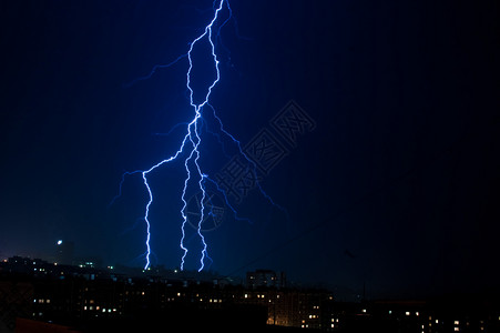 夜间在城市上空垂直闪电暴风图片