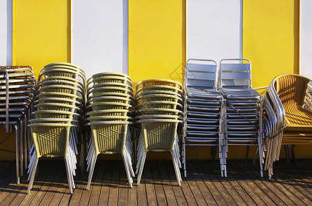 成群的桌子和椅子堆叠在一起用铁链绑在黄图片
