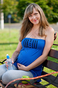 幸福的孕妇在户外公园长椅图片