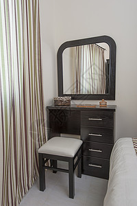 卧室里带凳子和镜子的梳妆台图片