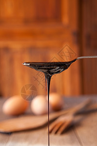 从茶匙中滴下的黑糖浆背景图片