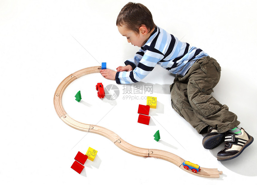 4岁的幼儿男孩玩木制火车打演播室背图片