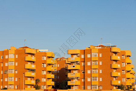 阳光下多层彩色的现代黄橙色建筑公寓街区群图片