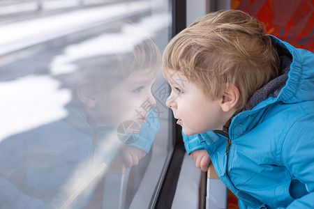 可爱的小男孩从火车窗外望着车窗当车图片