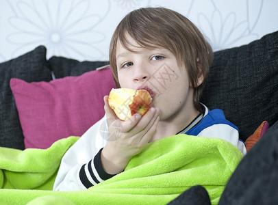 沙发上吃苹果的小男孩图片