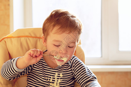 早上吃粥的两岁男孩的肖像图片
