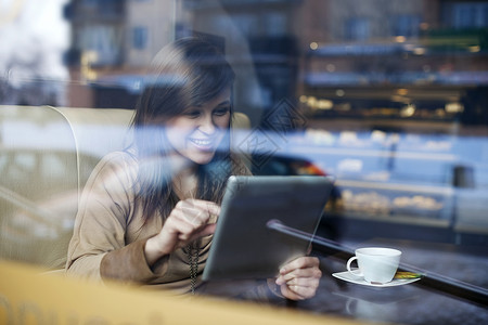 年轻女子在咖啡店使用平板电脑图片