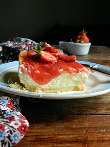 木桌上盘子里的草莓蛋糕图片