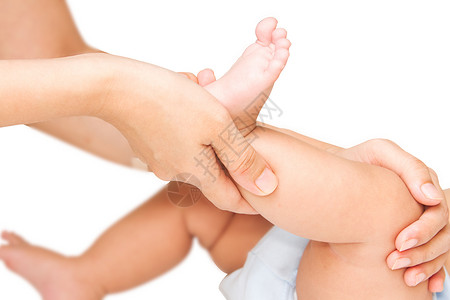母亲手按摩她婴儿的腿和脚肌肉图片