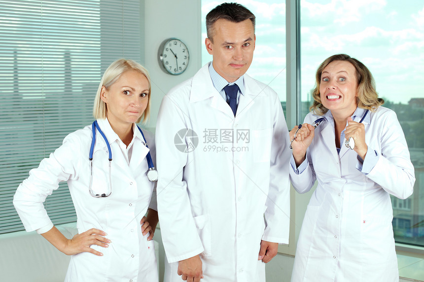 三名身穿白外套的临床医生以不同表达图片