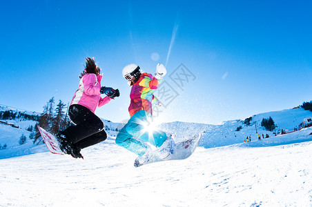 两个女孩玩跳跃和骑滑板图片