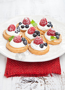一套美味的小型蛋糕上面有草莓和蓝莓图片