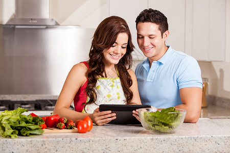 幸福的一对夫妇在网上用平板电脑高清图片