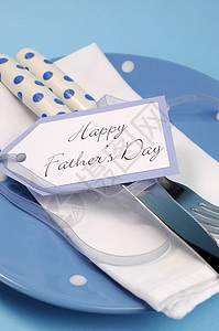 快乐的父亲日餐桌位置设关闭与蓝色波尔卡圆点板和餐具配有礼物标签信图片