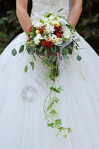 新娘拿着白色鲜花的婚礼花束图片