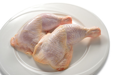 白盘子上的新鲜鸡腿背景图片