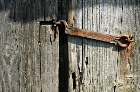 破旧的木门是封闭的生锈门闩图片