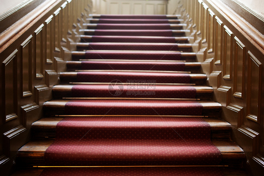 从空木制楼梯底部看到红色地毯在两侧盖面图片