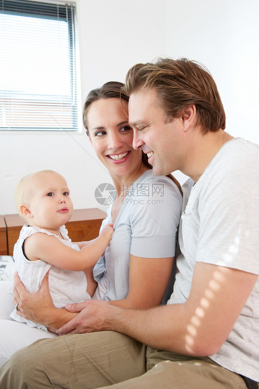 一位慈爱的父母与可爱的婴儿在家坐图片