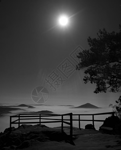满月之夜与日出在波希米亚萨克森瑞士美丽的山砂岩山峰和小山从有雾的背景中增加第一缕阳背景图片