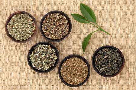 在柳条背景下选择人参茉莉圣约翰草荨麻和薄荷的绿茶叶图片